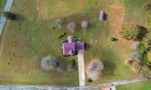Aerial view of a residential property and driveway leading to the road, with the layout considered in a lot survey